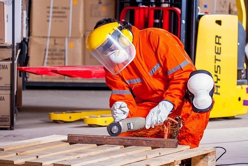 Pekerja menggunakan alat pelindung diri lengkap saat bekerja di area produksi
