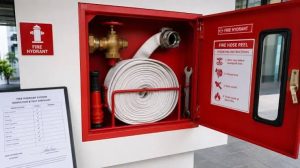 Fire hose reel terpasang di dalam kotak merah pada gedung perusahaan